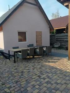 a table and chairs in front of a white building at Котедж ,,Чудовий" з Чаном in Novaya Greblya