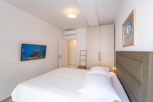 a bedroom with a bed and a tv on the wall at Apartments Irena in Cavtat