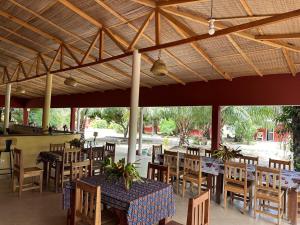 a restaurant with tables and chairs under a roof at Abené shuDyma lodge in Abémé