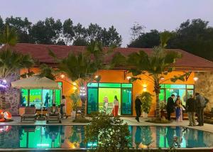 a group of people standing outside a house with a pool at Bài Văn Garden Homestay in Ba Vì