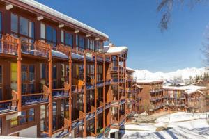 a large building with balconies and snow at Duplex arcs 1800 aux pieds des pistes in Arc 1800