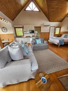un soggiorno con un divano e un letto di Maple Ridge Cottages a Dumbalk