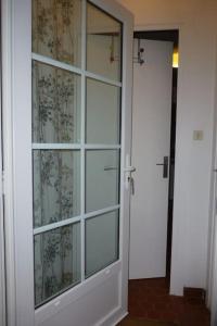 Puerta de cristal en una habitación con puerta en La Plumassière, en Saint-Genis-Laval