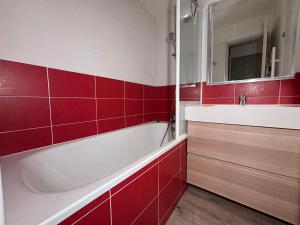 a red and white bathroom with a tub and a sink at Résidence Britania Clés Blanches in La Tania +34 photos