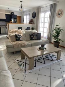a living room with a couch and a coffee table at Chambre dans maison près Disneyland Paris - 2 in Brie-Comte-Robert