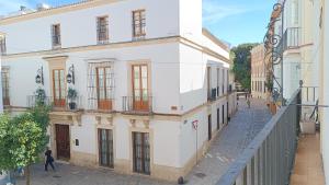 una mujer caminando por una calle al lado de un edificio en Sherryflat Torán, en Jerez de la Frontera
