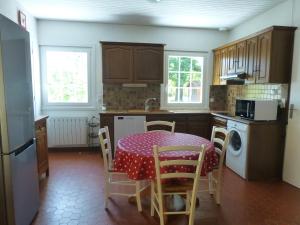una cocina con mesa y mantel de lunares en La Plumassière, en Saint-Genis-Laval