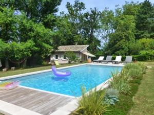 una piscina con un tobogán en un patio en La Plumassière, en Saint-Genis-Laval 2 fotos más