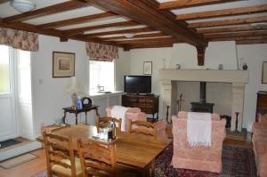 a living room with a table and chairs and a fireplace at Middlehead Cottages in Pickering