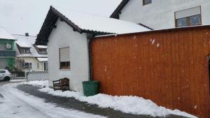 a house with a fence and a bench in the snow at Haus Eva in Eslarn