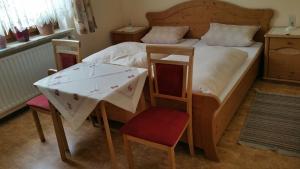 a bedroom with a bed with a table and chairs at Haus Eva in Eslarn