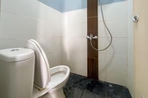 une salle de bain avec toilettes et douche dans l'établissement Andung Residence Lampung RedPartner, à Bandar Lampung