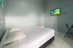 une chambre avec un lit avec une télévision au mur dans l'établissement Andung Residence Lampung RedPartner, à Bandar Lampung 24 autres photos