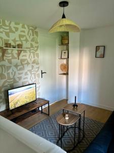 ロングペリエにあるLe Living Roissy CDGのテレビとテーブルのあるリビングルーム