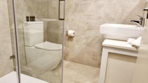 a bathroom with a toilet and a sink and a shower at Sunset Balcony Bass Coast Beach House in Grantville