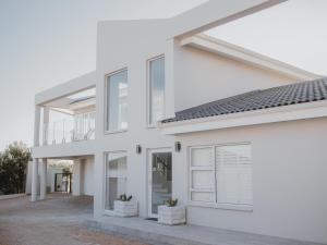 a white facade of a house with windows at KnusRus in Jongensfontein