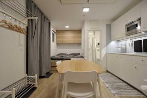 a kitchen and dining room with a table and a bedroom at FREE Ride cabins in Tösens