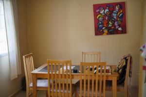 a dining room table and chairs with a painting on the wall at Dafa Tanga Lodge in Sanyang