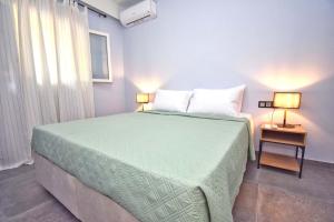 a bedroom with a large green bed with two lamps at Casa Campagnolo in Corfu