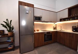 a kitchen with a stainless steel refrigerator and wooden cabinets at Casa Campagnolo in Corfu