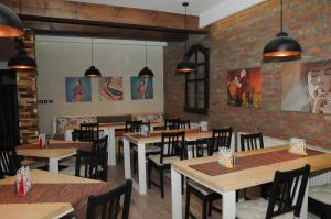 a restaurant with wooden tables and chairs and a brick wall at AS Apartments in Kopaonik