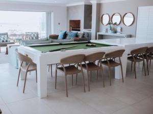 a living room with a pool table and chairs at KnusRus in Jongensfontein