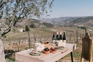 a table with bottles of wine and baskets of food at Feel Discovery Quinta do Muro Douro Valley in Peso da Régua