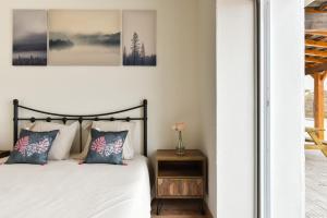a bedroom with a bed with two pillows and a table at Feel Discovery Quinta do Muro Douro Valley in Peso da Régua