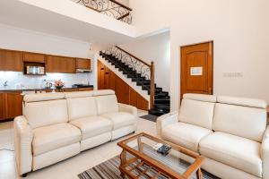a living room with two couches and a table at Susegad Suites Arpora Apartments & Villas with Reserved Parking in Arpora