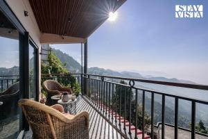 balcone con sedie e vista sull'acqua di StayVista at Ember Home with Balcony, Meals Available a Mussoorie