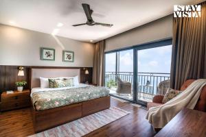 a bedroom with a bed and a balcony at StayVista at Ember Home with Balcony, Meals Available in Mussoorie