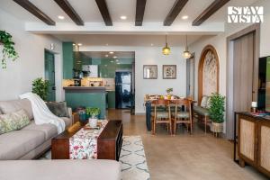 un soggiorno con un divano e un tavolo di StayVista at Ember Home with Balcony, Meals Available a Mussoorie