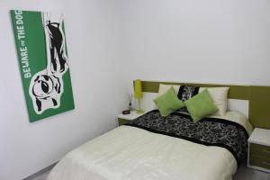 a bedroom with a white bed with green accents at Casa Los Islas in Playa del Ingles +56 photos