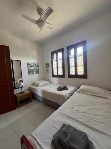 Un dormitorio con dos camas y un ventilador de techo. en Aspro Spiti 2, en Ormos Panagias