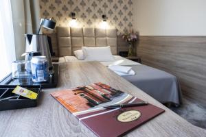 a hotel room with a bed and a book on a table at Hotel Maksymilian in Krakow