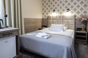a hotel room with two beds with towels on them at Hotel Maksymilian in Krakow