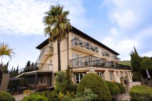 艾日Hôtel Eze Hermitage的一座前面有棕榈树的建筑