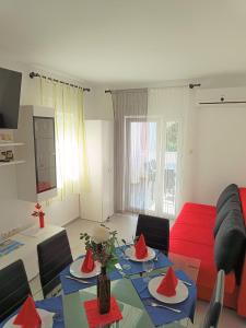 a living room with a table and a red couch at Apartment Mario, Novalja in Novalja