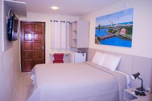 a bedroom with a bed and a door and a table at Pousada Elo Inn in Recife