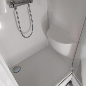 eine Dusche in einem kleinen Bad mit einem Waschbecken in der Unterkunft ty anna in Le Palais + 12 Fotos