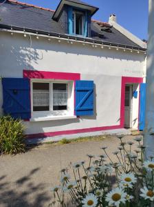 ein Haus mit blauen und rosa Fensterläden und Blumen in der Unterkunft ty anna in Le Palais