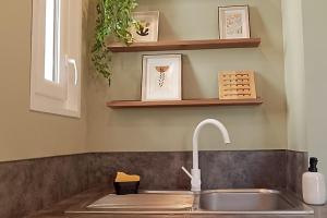 a kitchen sink with a faucet and some shelves at Maison l'Olivier in Nevers +27 photos