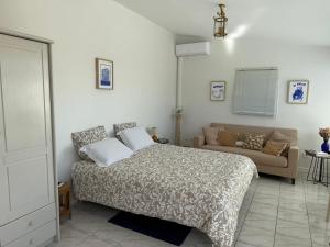 a bedroom with a bed and a couch at L'OASIS BLEUE spa et terrasse in Sète