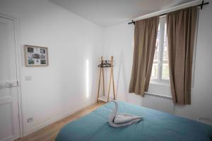 una camera da letto con un letto con un giocattolo a forma di cigno di Évasion Zen Tropic au Cœur de Châteaudun a Châteaudun