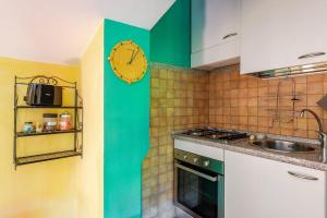 a kitchen with a clock on the wall next to a sink at Agriturismo La Torre dell'Oliveto in Agello +34 photos