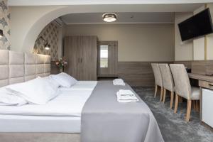 a hotel room with a bed and a table and chairs at Hotel Maksymilian in Krakow