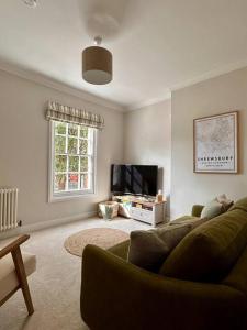 Una sala de estar con un sofá y un televisor de pantalla plana. en Charming Townhouse Retreat, en Shrewsbury
