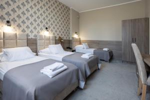 a hotel room with two beds with towels on them at Hotel Maksymilian in Krakow
