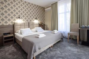 a hotel room with a large bed and a chair at Hotel Maksymilian in Krakow