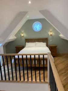 Chewton MendipにあるA space with amazing views and alpacas to enjoyのベッドルーム1室(窓のある屋根裏部屋のベッド1台付)